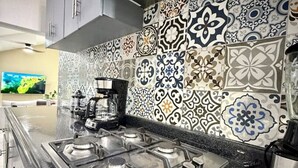 Una cocina moderna con estufa a gas, cafetera y microondas.
