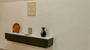 Una estantería exhibe un plato decorativo, una placa pequeña y un florero.