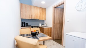 A compact kitchen with wooden cabinets, a coffee maker, a sink, and a refrigerator. - George's House in City center (Iraklio)