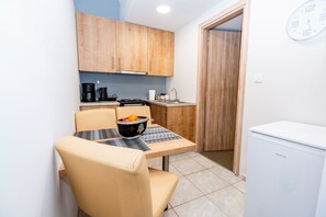 A compact kitchen with wooden cabinets, a coffee maker, a sink, and a refrigerator. - George's House in City center (Iraklio)