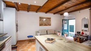 Een moderne keuken met houten balken, een eethoek met een houten tafel, en een gezellige zithoek met een bank.