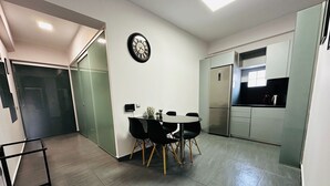 Una cucina moderna con frigorifero integrato e zona pranzo con tavolo rotondo e sedie.