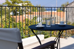 A balcony with a round table, a chair, and a metal railing.