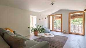 Una sala de estar moderna con un sofá verde, una mesita blanca y una planta en maceta.