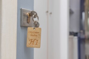 A keycard with "City Center Studios H1" engraved on it, attached to a keyhole on a door. - City Center Studio |H1 (Iraklio)