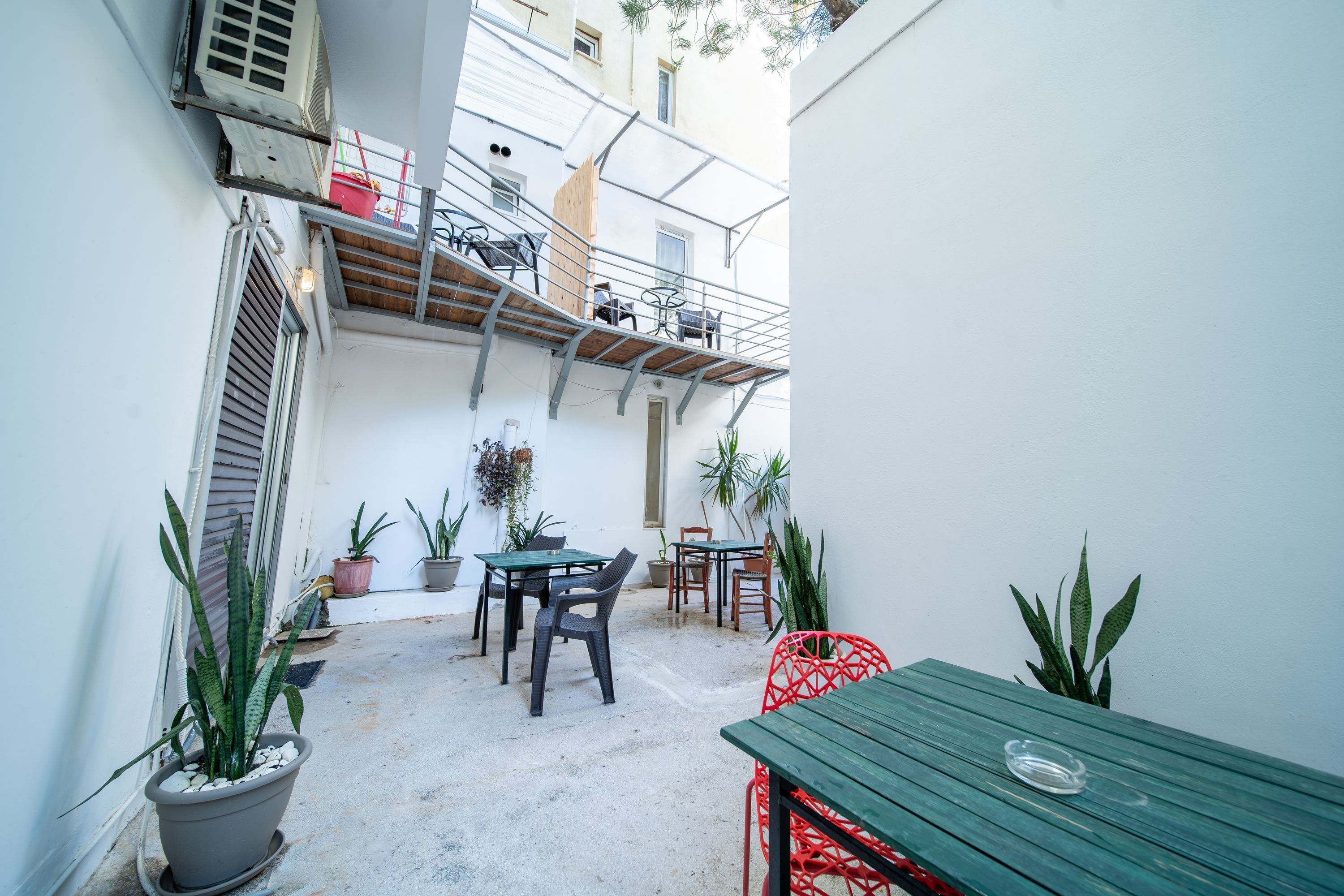 A courtyard with outdoor seating, potted plants, and a wooden table.