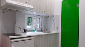 Eine Küche mit Marmorarbeitsplatten, einem eingebauten Herd und einer grünen Tür.