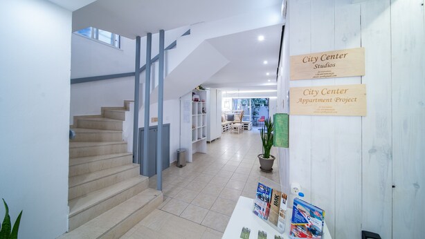 Ein modernes Interieur mit Treppe, einer Rezeption und Hinweisschildern.