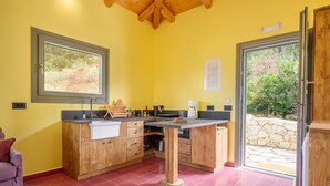 Eine Küche mit Holzausstattung, einer Arbeitsplatte und einem Fenster mit Blick auf einen Garten.
