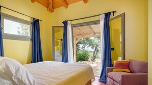 Ein Schlafzimmer mit Bett, Sofa und einem großen Fenster mit Vorhängen.