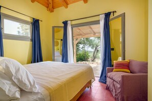 Ein Schlafzimmer mit Bett, Sofa und einem großen Fenster mit Vorhängen.