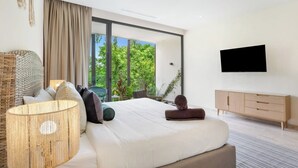 Un dormitorio moderno con una cama grande, televisión y vistas a zonas verdes.