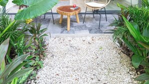 Ein modernes Haus mit Glasfassade, einer Küche und einer Sitzecke mit Tisch und Stühlen.