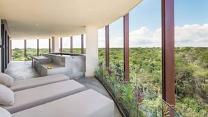 A modern outdoor lounge area with a pool, seating, and a view of a lush landscape. - Lavish 3 BD Apartment with Private Pool (Tulum)