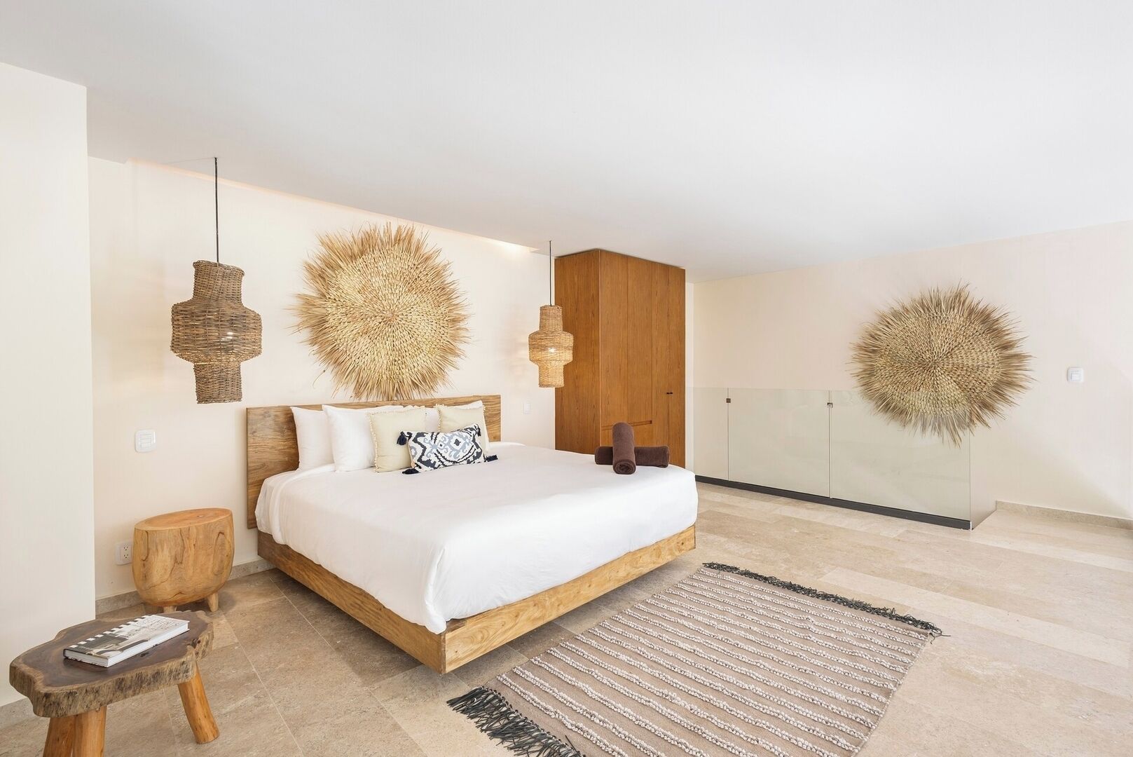 Een moderne slaapkamer met een groot bed, een houten hoofdbord en een glazen scheidingswand.