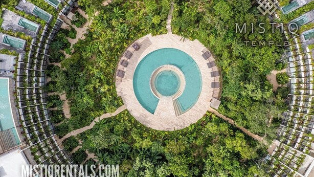 An aerial view of a resort with a central circular pool, surrounded by lush greenery and multiple swimming pools. - One of a kind! Loft with small pool (Tulum)