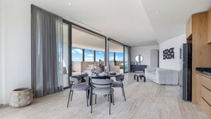 Un espace de vie moderne comprenant un coin repas, un canapé et une cuisine.