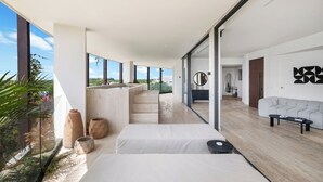 Un intérieur moderne avec un long couloir, un canapé et un coin repas.
