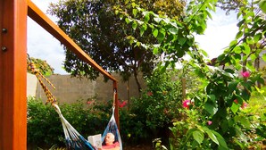 A hammock in a garden with a wooden structure, greenery, and a clear sky. - M&K House - KAR Double Room - 1 or 2 beds (Tarapoto)