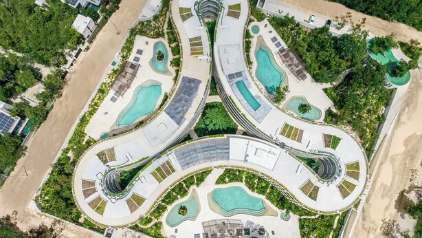 An aerial view of a resort with multiple swimming pools, winding pathways, and lush greenery. - Jungle view studio, AC, Wifi , Several Pools (Tulum)