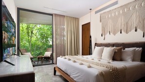 A modern hotel room with a large bed, a TV, a balcony with a chair, and a macrame wall hanging. - Exclusive 2 bd with pool and street view! WiFi and AC (Tulum)