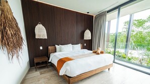 Ein modernes Schlafzimmer mit einem großen Bett, einem Holz-Kopfschild, zwei Nachttischen und Blick auf Grün durch große Fenster.