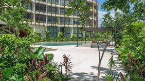 Ein modernes Hotel mit Pool und üppiger Bepflanzung.