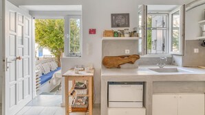 Una cocina moderna con un amplio ventanal, una tabla de madera en la encimera y un lavavajillas integrado.