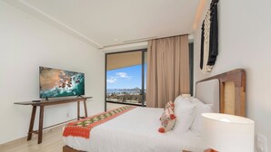 Ein Hotelzimmer mit einem Bett, einem Fernseher auf einem Schrank, einem großen Fenster mit Blick und einer Lampe.