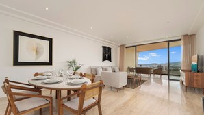 Ein modernes Wohnzimmer mit Essbereich, einer Couch und Blick ins Freie.