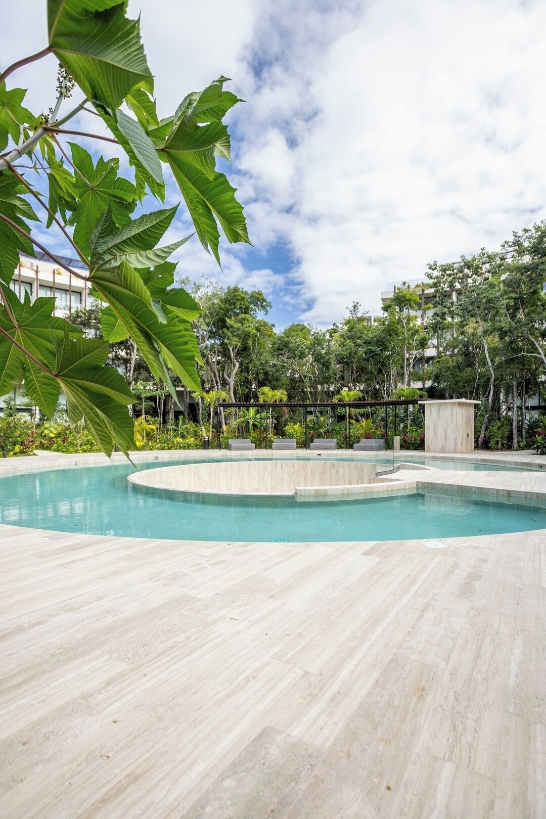 A swimming pool with a curved design, surrounded by a tiled deck.