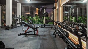 Een sportschool met diverse fitnessapparaten, waaronder gewichten en krachttoestellen.
