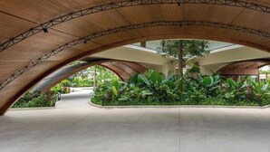 Een ruimte met een gebogen houten plafond en een centrale tuin.