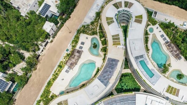 A resort with multiple swimming pools, winding walkways, and solar panels. - Astounding Loft with Gym, Pool and Beach Shuttle (Tulum)