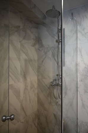 A modern shower with a handheld showerhead and a wall-mounted faucet, set against marble tiles. - Athenian Stay 303 Apartment (Athina)