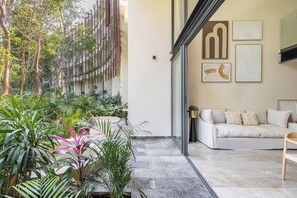Un salon moderne avec un canapé blanc, une table basse et une plante en pot.