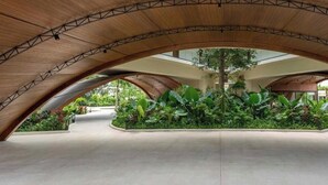 Un espacio interior con techo de madera curvada y un jardín central.