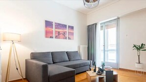 Un salon moderne avec un canapé gris, une lampe sur pied, une table basse et une plante en pot.