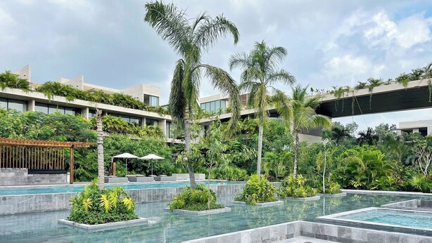 A modern hotel with multiple swimming pools surrounded by lush greenery and palm trees. - 1st Floor Sanctuary | Pool Views, Hammock and Washer (Tulum)