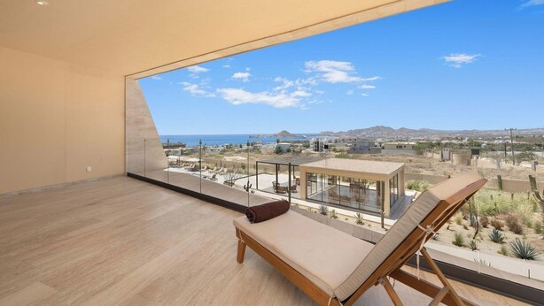 Een ruim balkon met een helder uitzicht op de oceaan en het woestijnlandschap.