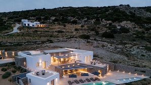 A modern villa with a pool, outdoor seating, and a view of the surrounding landscape. - Aegean Hestia Luxury Villa of Paros (Paros)