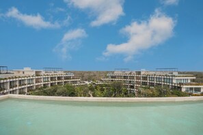 Ein modernes Resort mit Pool, mehreren Stockwerken und freiem Blick auf die umliegende Landschaft.