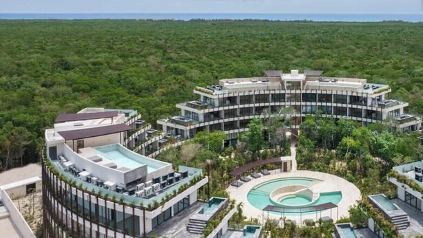 A modern resort with a central pool, multiple guest rooms, and lush greenery surrounding the property. - Loft w/ Private Patio, 7 Pools, Gym and WiFi and AC (Tulum)