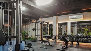 A gym with various exercise equipment, including weight machines and dumbbells. - Luxury Studio near Tulum beach, fast WI-FI and AC! (Tulum)