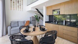 Eine moderne Küche mit schwarzer Arbeitsplatte, Holzschränken und einer eingebauten Mikrowelle.