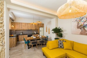 Une cuisine moderne avec des meubles en bois et un coin repas comprenant un canapé et des chaises jaunes.