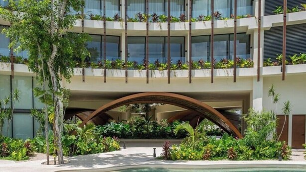 A multi-story hotel with balconies, a pool, and lush landscaping. - Top summer retreat! Studio with pool and rooftop! (Tulum)