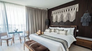A bedroom with a bed, bedside tables, a bench, a small table, and curtains. - Top summer retreat! Studio with pool and rooftop! (Tulum)