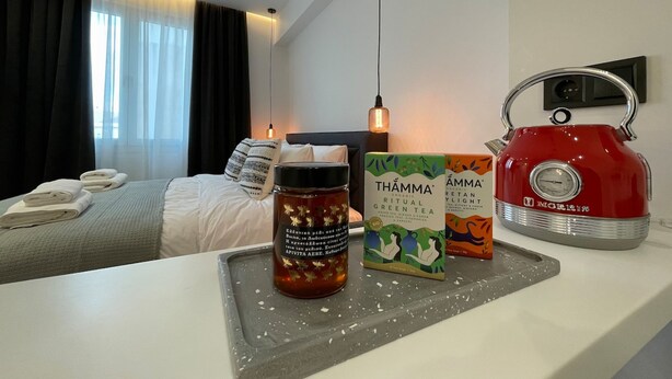 A hotel room with a bed, a tray table with tea and tea bags, and a kettle on the counter. - Monastiraki 513 @SuperHost Hub (Athina)