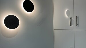 A modern interior with circular wall sconces and a white cabinet with silver handles. - Monastiraki 513 @SuperHost Hub (Athina)